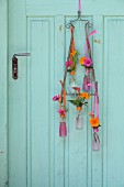 Flower arrangement in Campari bottles hung from vintage door