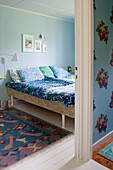 Blick ins Schlafzimmer in Blautönen mit Retro-Bettwäsche