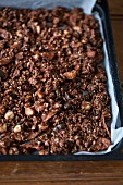 Homemade chocolate granola with seeds and nuts on a baking tray