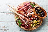 Antipasto Platter Cold meat plate with grissini bread sticks on wooden background