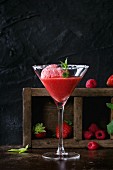 Sugared cocktail glass of strawberry dessert with sorbet, served on dark background with Strawberries