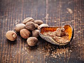Grated nutmeg on dark wooden background