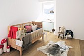 Wooden bed and fur rug in rustic child's bedroom