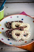 Sprinkle biscuits (carnival mask) with chocolate glazes and colourful sugar beads