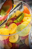 Fruit gummy wheels in a glass jar with tongs