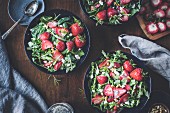 Three bowls of strawberry, spinach and arugula salad