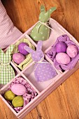 Dyed Easter eggs and hand-made egg cosies in old wooden crate