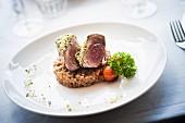 Tuna in a pistachio crust on a bed of spelt and vegetables
