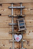 Lantern and heart-shaped decoration hung from trellis on wooden façade