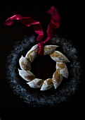 An artisan bread wreath with a red satin ribbon