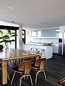 Wooden table and classic chairs in open-plan kitchen-dining room