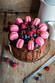 Chocolate cake decorated with berries and macarons
