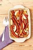 Sausages baked with onion, apple and apricot jam