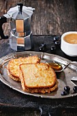 Grilled Toasts with honey, blueberries, cup of coffee espresso and coffee pot