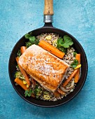 Fillet of salmon on a bed of buckwheat with carrots, coriander, broccoli and yellow pepper