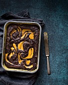 Gluten-free brownie and pumpkin cake in a baking tin