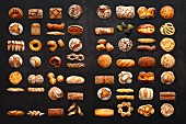 Viele verschiedene Brote auf dunklem Untergrund (Aufsicht)