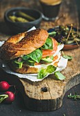 Breakfast with bagel with salmon, avocado, cream-cheese, basil and espresso coffee