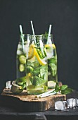 Citrus fruit and herbs infused sassi water for detox, healthy eating or dieting in glass bottles with straws