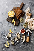 Open Oysters with bread and butter and champagne on gray concrete texture background