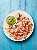 Prawns shrimps with Guacamole fresh dip on plate on blue background
