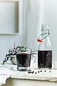 Homemade elderberry juice in a bottle and a glass