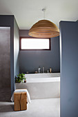Blick auf Badewanne und Fenster im Badezimmer mit grauen Wänden