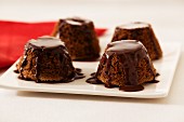 Four small chocolate cakes with chocolate sauce