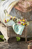 Bouquet of cow parsley, red campion and buttercups and swing-top bottle with wild-flower wreath in wicker basket
