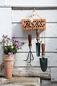 Garden tools hung from canes in brick