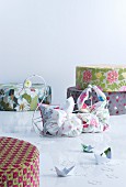 Colourful pouffes and fabric bags in metal swan-shaped basket