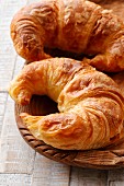 Two croissants in a wooden bowl