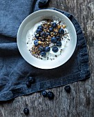 Yoghurt muesli with blueberries, blueberry powder, oat flakes and seeds