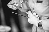 A kitchen aid polishing silverware in a restaurant