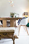 Moderne Schalenstühle und ein alter Hocker um einen Holztisch