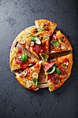 Pizza mit Pilzen, Salami und Lauch auf Schneidebrett