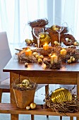 Wildkrautkränzchen mit goldenen Kugeln und Kerzen als weihnachtliche Tischdekoration