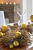 Festliche Tischdekoration mit getrockneten Kränzen und goldfarbenen Kerzen