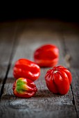 Four Habanero chillies on a wooden background
