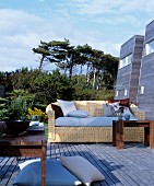 Comfortable wicker sofa and wooden tables on wooden terrace