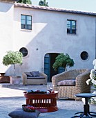 Mediterranean courtyard furnished with rattan seating and red coffee table