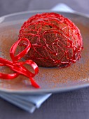 Kupelförmiges Schokoladeneisdessert unter rotem Zuckergespinst