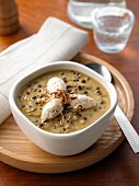 A bowl of lentil soup with chicken breast quenelles