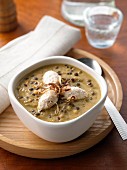 A bowl of lentil soup with chicken breast quenelles