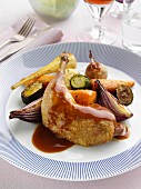 A roast leg and thigh of guinea fowl and vegetables