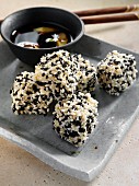 Deep fried tofu coated in black and white sesame seeds dipping sauce