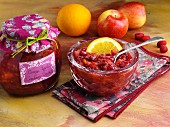 Hausgemachte Cranberrysauce mit Äpfeln und Orangen in Einmachglas und Schälchen