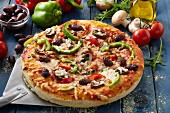 Selbstgemachte Pizza mit Paprika, Pilzen und Oliven