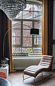 Leather couch and arc lamp in front of old lattice window