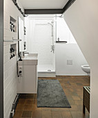 Weißes Badezimmer mit braunem Fliesenboden und Sichtmauerwerk
